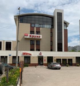 a building with a car parked in a parking lot at Cruise Hotel in Perm