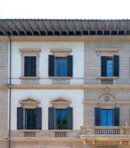a facade of a building with blue shutters at Giardino D'Azeglio Locazione Turistica in Florence