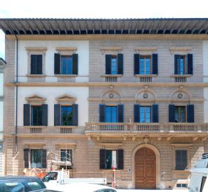 ein Gebäude mit vielen Fenstern und einer Holztür in der Unterkunft Giardino D'Azeglio Locazione Turistica in Florenz