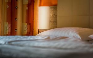 a bed with a white pillow and a lamp at Sonnenhof Hechtl in Mönichkirchen