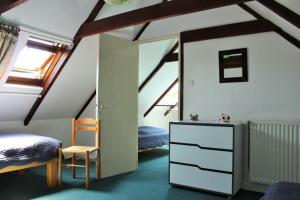 a bedroom with two beds and a dresser in a attic at Sue's cottages in Pleuven