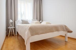 ein weißes Bett in einem weißen Schlafzimmer mit einem Fenster in der Unterkunft Apartament GORZÓW in Gorzów Wielkopolski