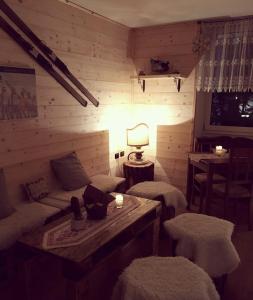 Habitación con sofá, mesa y lámpara. en Albergo Aprica Garni, en Aprica