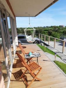 a wooden deck with a table and a swing at Apartament na Morskim Wzgórzu in Mechelinki