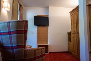 A television and/or entertainment centre at Familienhotel Gasthof Hinteregger