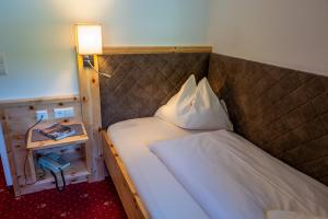 A bed or beds in a room at Familienhotel Gasthof Hinteregger