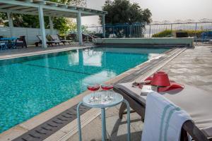 two glasses of wine on a table next to a swimming pool at Sea of Galilee Panoramic View in Moshav Ramot