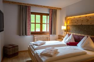 A bed or beds in a room at Familienhotel Gasthof Hinteregger