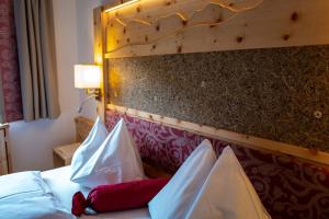A bed or beds in a room at Familienhotel Gasthof Hinteregger