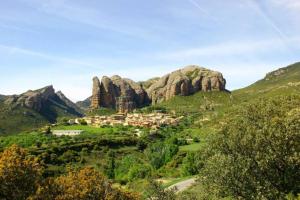uma pequena aldeia num vale de montanha com rochas em APARTAMENTO FONTELLAS-AYERBE em Fontellas