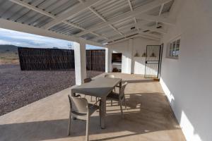un tavolo e sedie su un patio con vista di Kransplaas - Springbok Cottage a Adendorp