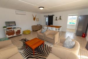 un soggiorno con un divano e un tavolo di Kransplaas - Springbok Cottage a Adendorp Altre 19 foto