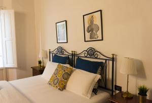 una camera da letto con un letto con cuscini blu e bianchi di Dante's Rooms a Firenze