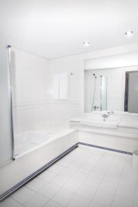 a white bath tub sitting next to a white sink at Park Plaza Suites Apartamentos in Marbella