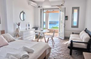 a bedroom with a bed and a table and a view of the ocean at Villa Von Sophia in Petriaí