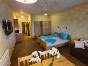 ein Schlafzimmer mit einem Bett, einem Sofa und einem Tisch in der Unterkunft Apartmaji Bršca in Begunje