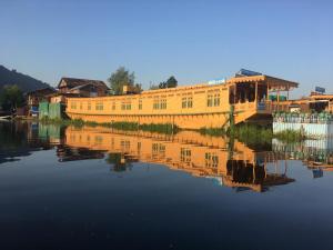 a yellow building sitting on top of a body of water at Young Beauty Star Houseboat in Srinagar