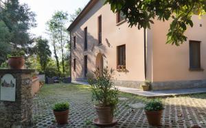 un bâtiment avec des plantes en pot devant lui dans l'établissement Locanda degli Alberi, à Sassetta