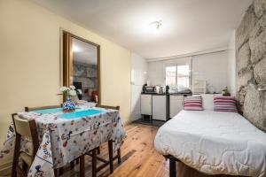 1 dormitorio con cama, mesa y cocina en Metro Casa Música Apartments and Rooms, en Oporto