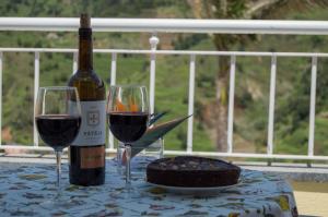 Una botella de vino y dos copas en una mesa. en Terrace View House (Cantinho das Feiteiras) en São Vicente