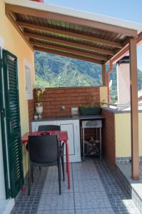 un patio con mesa, sillas y chimenea en Terrace View House (Cantinho das Feiteiras) en São Vicente