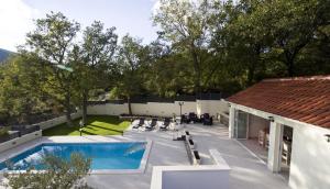 a backyard with a swimming pool and a house at VILLA SKURA private heated pool 32m2, summer kitchen, 4 bedrooms, garden in Duće
