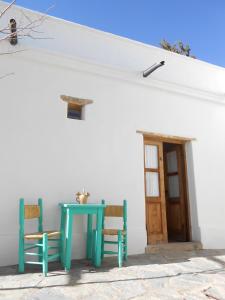 a blue table and two chairs in front of a white house at Hosteria Villa Cardon in Cachí