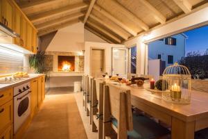 a kitchen with a large wooden table with chairs at VILLA SKURA private heated pool 32m2, summer kitchen, 4 bedrooms, garden in Duće