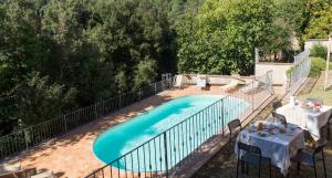 a swimming pool with a table and chairs next to it at Locanda degli Alberi in Sassetta