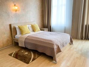 a bedroom with a large bed with yellow pillows at City Inn Riga Apartment, Old Town History Heritage with parking in Riga