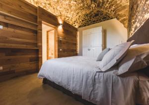 a bedroom with wooden walls and a bed with pillows at Torre di Baratti Bio Resort in Populonia