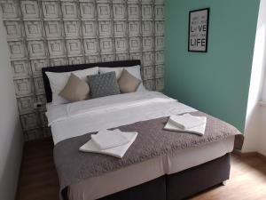 a bedroom with a large bed with two pillows on it at Piraneska in Piran