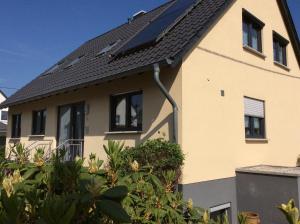 uma casa com painéis solares no telhado em Ferienwohnung Sternfeld em Osburg