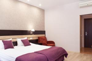 Un pat sau paturi într-o cameră la Dynasty Hotel
