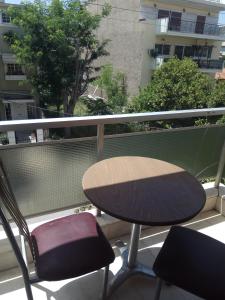 een tafel en 2 stoelen op een balkon bij Omiros in Piraeus