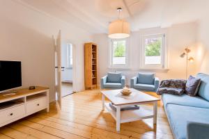 ein Wohnzimmer mit einem blauen Sofa und einem TV in der Unterkunft Ferienwohnung Bad Sachsa Harz in Bad Sachsa