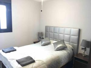 um quarto com uma cama com duas almofadas em Apartamento Girasol em Ardales