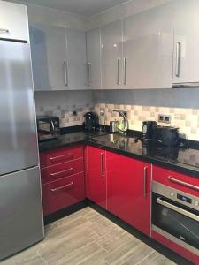 eine Küche mit roten Schränken und Edelstahlgeräten in der Unterkunft Apartamento Girasol in Ardales