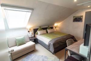 ein Schlafzimmer mit einem Bett, einem Sofa und einem Fenster in der Unterkunft Hotel-Restaurant-Weingut Kapellenhof in Klotten