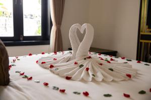 a wedding dress in the shape of a swan on a bed at Silkotel Hoi An in Hoi An +75 photos