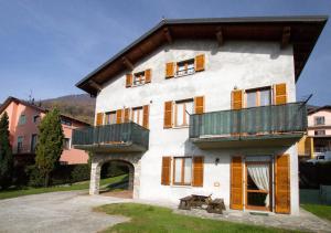 a large white building with wooden windows and a balcony at Guest House Il Nido dello Svasso -Foresteria Lombarda- in Sorico