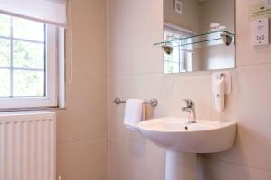 La salle de bains est pourvue d'un lavabo, d'un miroir et d'une fenêtre. dans l'établissement Abbey Fields By Chef & Brewer Collection, à Kenilworth