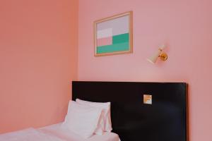 ein Schlafzimmer mit einem Bett und einem Bild an der Wand in der Unterkunft Hotel Am Brillantengrund in Wien