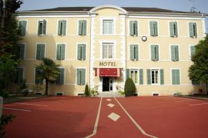 un hotel con un estacionamiento rojo delante de él en The Originals Boutique, Villa Montpensier, Pau (Inter-Hotel), en Pau