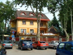 a building with cars parked in front of it at Herczeg Apartment in Miskolctapolca