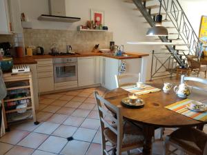 a kitchen with a table and chairs and a staircase at La Forge in Signes