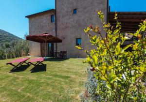 a picnic table and an umbrella in the yard of a building at Torre di Baratti Bio Resort in Populonia