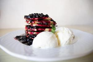 a dessert with blackberries and ice cream on a white plate at Metropolis Hotel in Saint Petersburg