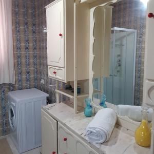 a white bathroom with a sink and a mirror at CASA CALISI in Terrasini