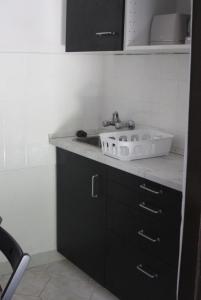a bathroom with a sink and a black cabinet at Pajtás Vendégház in Örvényes +45 photos